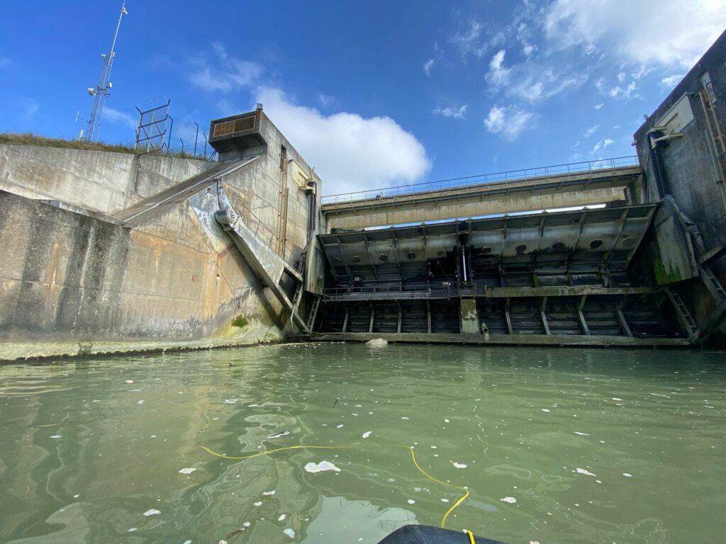 Intervention ROV au pied d'un ouvrage hydraulique à vannes, vue depuis le plan d'eau